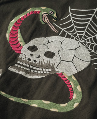 Olive jacket close-up of front skull illustration with web and striped snake accents