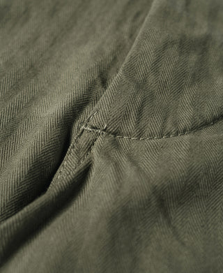 Olive utility pants with stitched hem and layered pocket seam detail