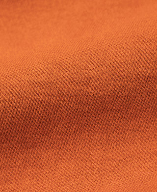 Orange knit sweatshirt fabric close-up with fine textured weave