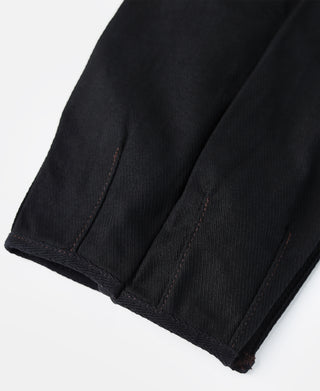 Black fabric detail on riding breeches leg with visible seam and textured weave