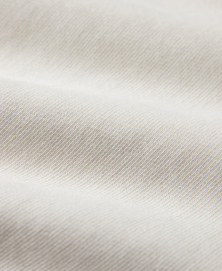 White sweatshirt fabric with fine knit texture and ribbed collar seam detail.