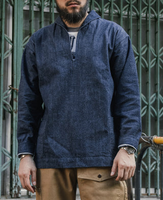 Indigo dungaree pullover jumper with zip-front worn over tan trousers