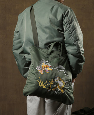Olive embroidered helmet bag worn crossbody with dragon and tiger graphic