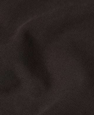 Close-up of dark contrast sleeve fabric on the orange quarter-zip long-sleeve T-shirt