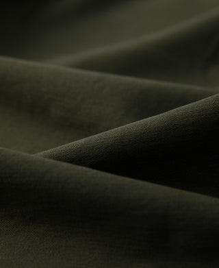 Olive fatigue utility shirt fabric close-up, textured weave and seams
