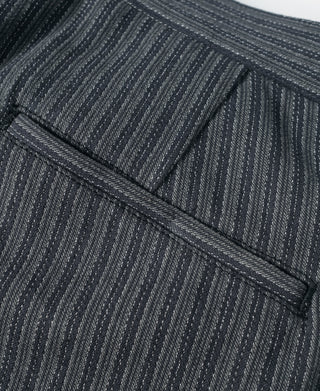 Front pocket area with stitched trim on black and gray striped pants