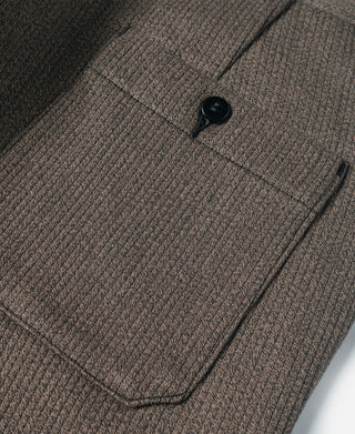 Brown striped pants close-up of center button and front pocket seam
