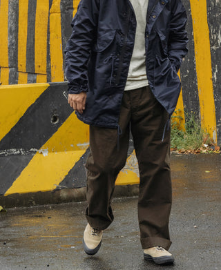Dark brown combat pants with tapered stance, side pockets, and cuffed hems