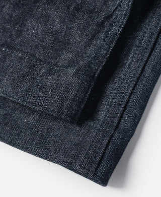 Dark navy denim leg panel with stitched hem and pocket edge detail