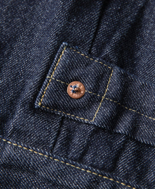 Indigo denim jacket pocket with stitched square flap and copper button