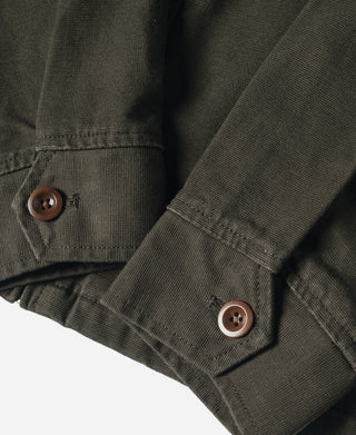 Olive jacket sleeve cuff with brown button and stitched pocket edge