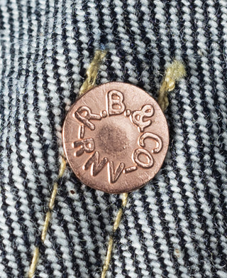 Copper logo button on indigo striped denim with contrast yellow thread
