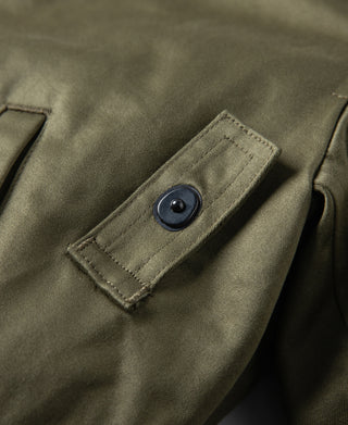 Olive flight jacket chest pocket with dark button closure.