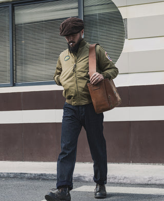 Khaki olive tanker jacket with sleeve patch, worn with dark cap