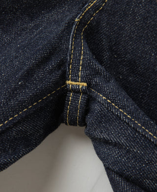 Indigo denim jeans pocket edge seam with bar-tack detail and yellow stitching