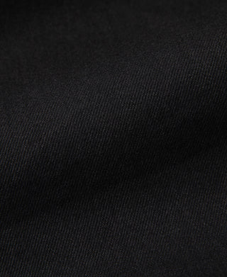 Black selvedge denim fabric close-up with fine woven texture