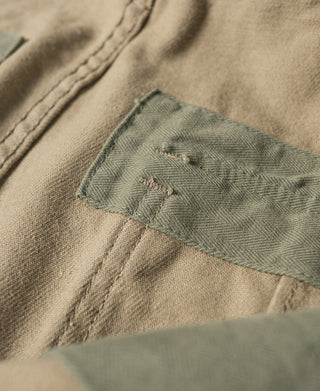 Khaki pants fabric close-up with stitched inside pocket and bartack stitching.