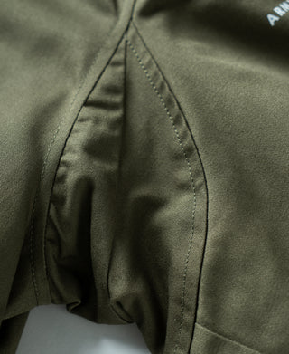 Olive flight jacket inner side panel with curved pocket seam and stitched edge