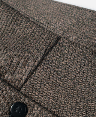 Brown striped pants side view with pocket flap, seam lines, and dark button