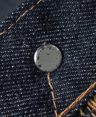 Indigo selvedge denim fabric close-up with orange-brown contrast stitching