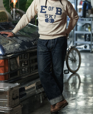 Apricot long-sleeve sweater with large blue 'E OF B' ski graphic on chest
