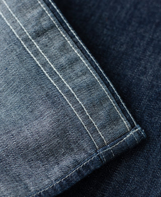 Indigo denim work shirt cuff, stitched seam detail and textured denim