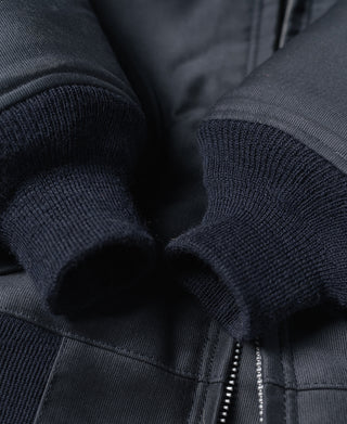 Navy deck jacket zipper area with knit cuffs and fabric panel close-up
