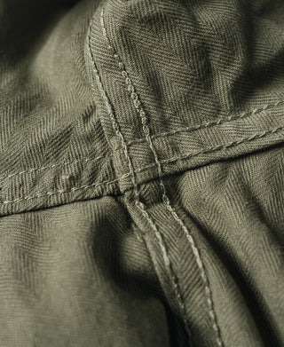 Olive utility pants with reinforced stitching at waistband and pocket opening