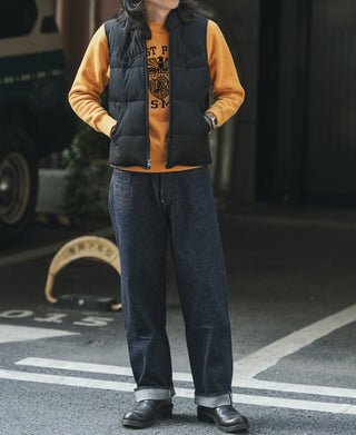 Black quilted padded vest worn over a top; front zipper visible.