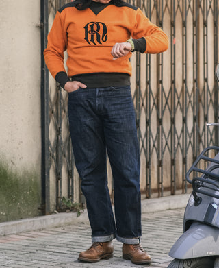 Orange and dark two-tone sweatshirt with V-inset neckline, worn with jeans.
