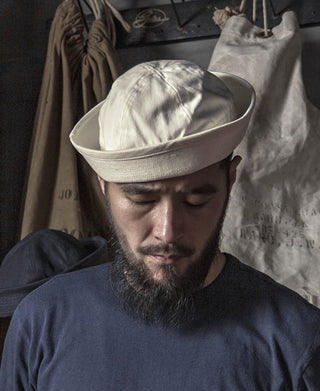 White dixie cup hat worn by person with short brim