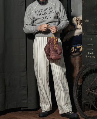Gray crewneck raglan sweater with 'Physical Training 365' worn with striped pants.