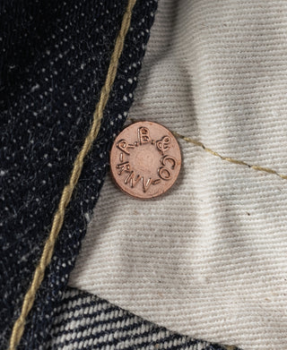 Indigo denim jeans copper coin button on light inner waistband lining