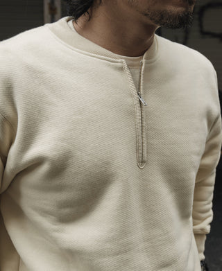 Apricot half-zip fleece sweatshirt neckline with ribbed trim and metal zipper pull