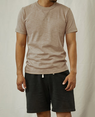 Light tan crewneck cotton T-shirt on model with dark shorts