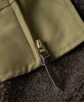 Khaki flight jacket zipper pull with leather tab on dark knit lining