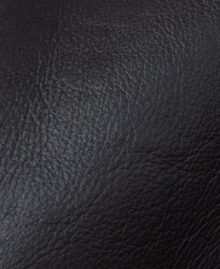 Dark grain leather flight jacket panel with textured surface and seam lines
