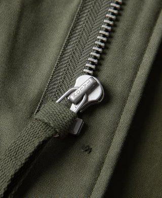 Olive field jacket zipper pull with metal hardware and stitched zipper tape
