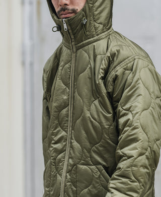 Olive hooded quilted jacket detail with full zipper, stand collar, and padded shoulders