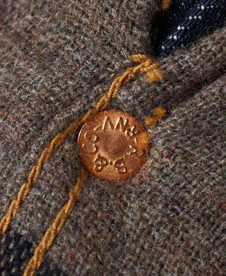 Indigo denim jacket with brown leather-look brand patch on plaid-lined cuff