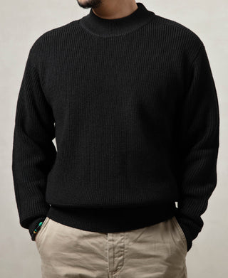 Black wool crewneck sweater worn on model, ribbed neckline and long sleeves