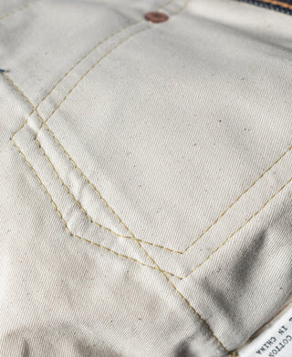 Off-white denim pocket lining with contrast topstitching and folded seam