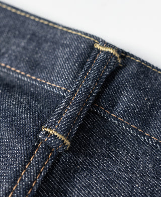 Dark blue selvedge denim jeans pocket seam with orange-brown contrast stitching