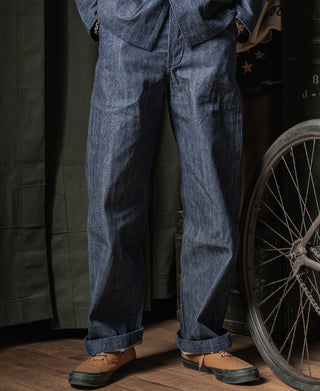 Indigo denim trousers worn with brown leather shoes, straight leg cuffs