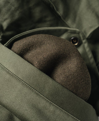 Olive field jacket interior pocket with snap closure, fabric texture close-up