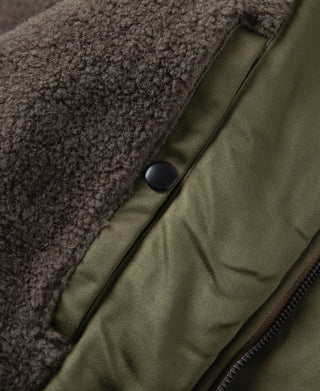Olive flight jacket with dark snap button and plush collar lining.