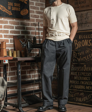 Cream henley T-shirt with short sleeves and 3-button placket, worn with dark pants