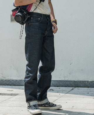 Indigo denim jeans on model with cuffed hem and visible pocket stitching