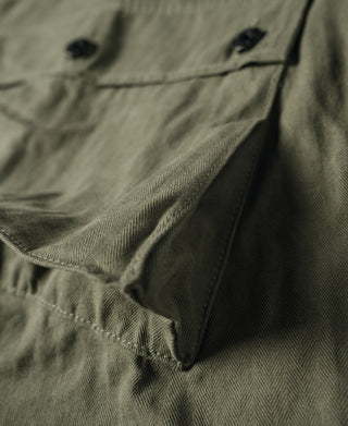 Olive utility pants with side pocket flap and angled seam detail