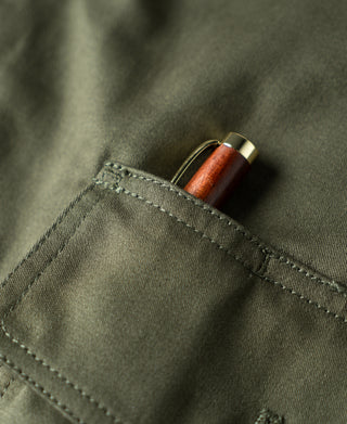 Olive flight jacket pocket opening with visible thread spool inside